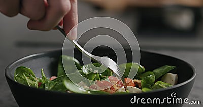 Closeup eating fresh salad with mozzarella and cherry tomatoes with fork Stock Photo