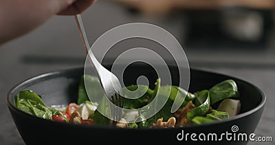 Closeup eating fresh salad with mozzarella and cherry tomatoes with fork Stock Photo