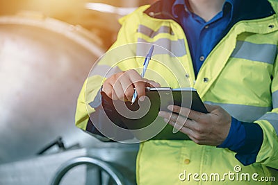 Closeup engineer staff worker with checking schedule listing write record maintenance replace service date Stock Photo