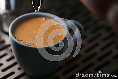 Closeup espresso last drop with single spout portafilter in blue cup Stock Photo