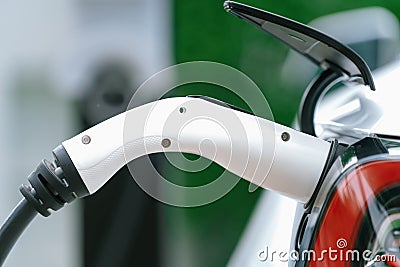 Closeup EV charger plug handle attached to electric vehicle port. Synchronos Stock Photo