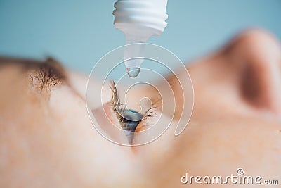 Closeup of eyedropper putting liquid into open eye Stock Photo