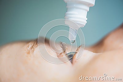 Closeup of eyedropper putting liquid into open eye Stock Photo