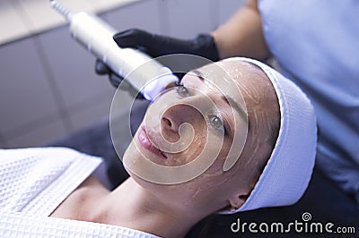 Closeup of face of beautiful relaxing girl undergoing hardware cosmetology procedure in spa Stock Photo