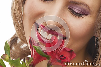 Closeup of face of young smiling woman with bunch of flowers Stock Photo