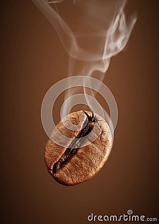 Closeup falling coffee bean with smoke on brown background Stock Photo