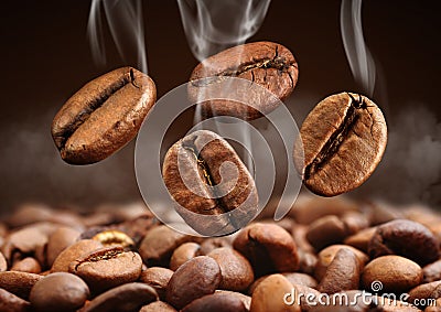 Closeup falling coffee bean with smoke on brown background Stock Photo