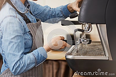 Closeup of female barista cleaning bottomless portafilter with steamer. Stock Photo