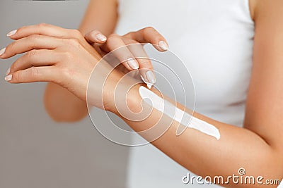 Closeup of female hands applying hand cream.Hand Skin Care. Women use body lotion on your arms. Beauty And Body Care Concept. Stock Photo