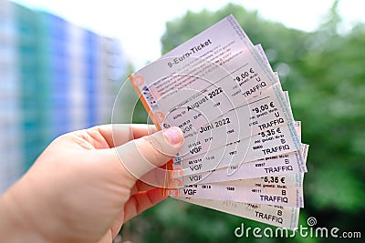 Closeup female hands hold many tickets, monthly travel passes in germany for all modes of public transport, travel concept for Editorial Stock Photo