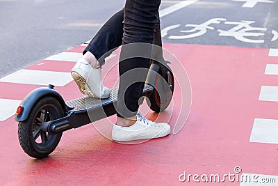 Young woman with colored dreadlocks riding electric scooter Stock Photo