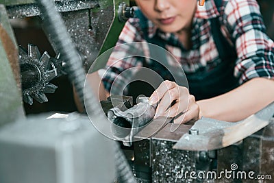 Closeup of female worker milling steel components Stock Photo