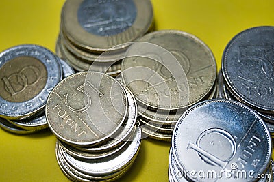 Closeup Hungarian Forint FT HUF coins stacked up in a pile laying on yellow background Stock Photo