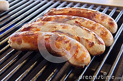 Closeup of the four sausages on the grill Stock Photo