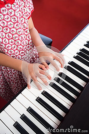 Closeup girl hand playing piano. Favorite music for learning to basic of music and rhythm skill. Stock Photo