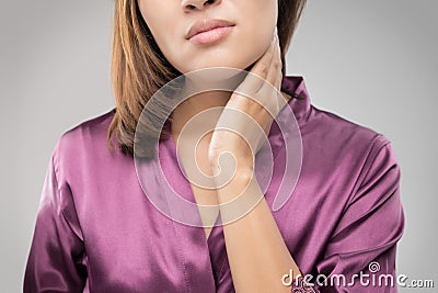 Closeup girl with sore throat touching her neck. Stock Photo