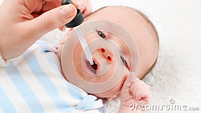 Closeup of giving vaccine to newborn baby boy from eyedropper or syringe. Concept of babies and newborn vaccination and Stock Photo