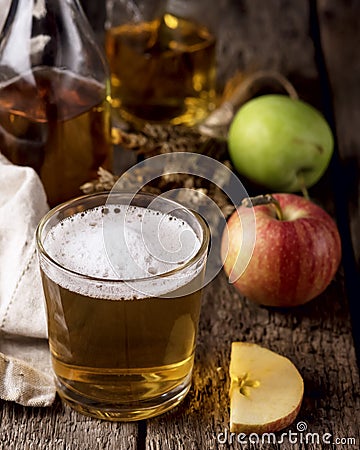 Closeup of a Glass of Cider with Ripe Apples Wooden Background Vertical Stock Photo