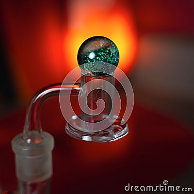 Closeup of a glass smoking banger on blur red background Stock Photo