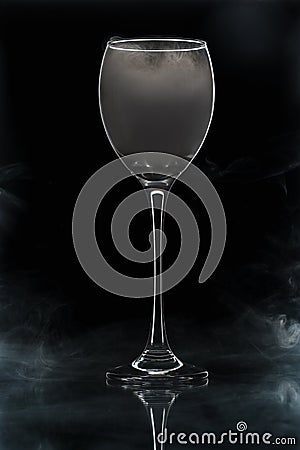Closeup glass with white fog at dark background. Chemical reaction of dry ice with water Stock Photo