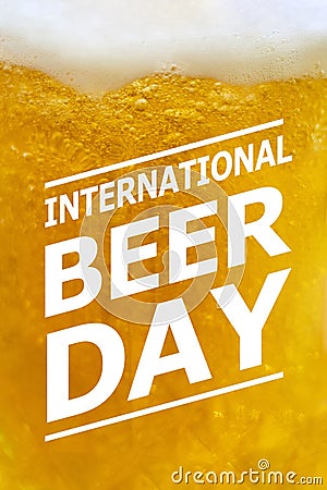 Closeup of a glass of yellow foamy craft beer with international Beer day text Stock Photo