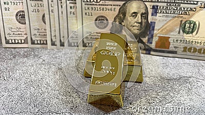 Closeup of a gold with the pile of American dollars banknotes in the background Editorial Stock Photo
