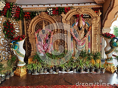 Closeup of Golden Color Lord Venkateshwara and his wife Goddess Lakshmi Statue at the entrance of Wedding Hall or Kalyana Mantapa Editorial Stock Photo