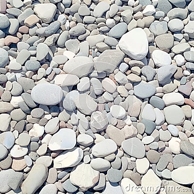 Closeup gray pebbles scattered on a peaceful beach Stock Photo