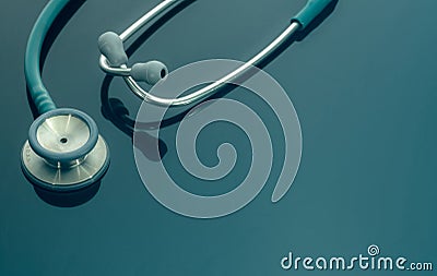 Closeup green stethoscope on doctor table or nurse desk. Health checkup or health insurance concept. Cardiology doctor equipment. Stock Photo