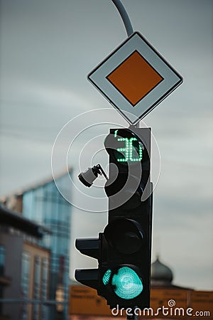 Closeup of a green traffic light for cars and the main road sign; 30 seconds left Stock Photo