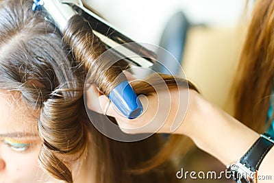 Closeup of hairdresser doing the styling for a festive evening of wedding hairstyles woman with long black hair Stock Photo