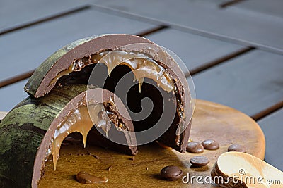 Closeup of a half of a cut, double-shelled Easter egg ovo de Pascoa stuffed with melted caramel and biscuit, decorated with Stock Photo