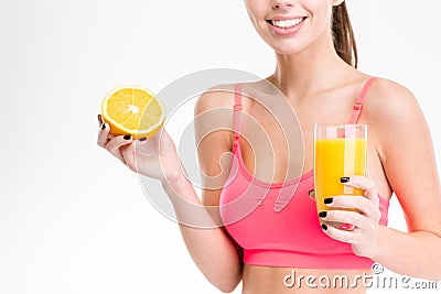 Closeup of half orange and juice holded by fitness woman Stock Photo