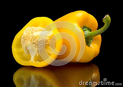 Closeup halved yellow bell peppers isolated on black Stock Photo