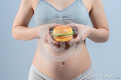 Closeup of hamberger junk food and pregnant woman is not good healthy for mother and infant Stock Photo