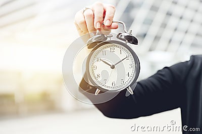 Closeup hand holding alarm clock for working time aware or realize in lifestyle Stock Photo