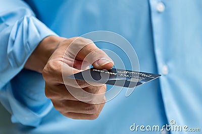 Closeup of hand holding and giving credit card for payment Stock Photo