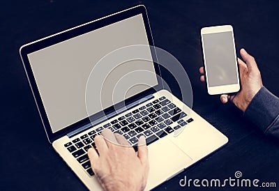 Closeup of hand holding mobile phone with computer laptop background Stock Photo