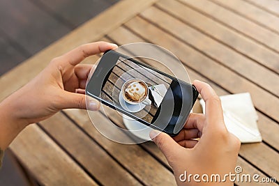 Closeup hand holding phone mobile taking photo coffee on table Stock Photo