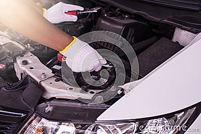 Closeup of hand mechanic engineer fixing car battery at garage Stock Photo