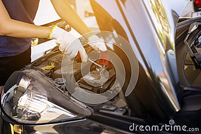 Closeup of hand mechanic engineer fixing car battery at garage Stock Photo