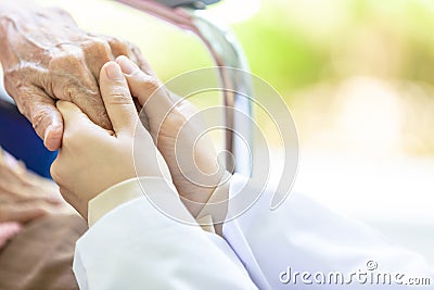 Closeup of hand medical female doctor or nurse holding senior patient hands and comforting her,.Caring caregiver woman supporting Stock Photo