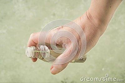 Closeup hand of a person holding bottle of cologne Stock Photo