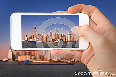 Closeup of a hand with smartphone taking a picture of Shanghai skyline and the Huangpu river China Stock Photo