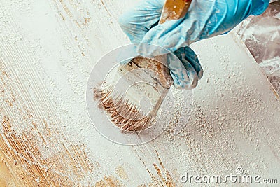 Closeup hand use brush paint white on wood surface Stock Photo