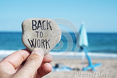 Folded beach umbrella and text back to work Stock Photo