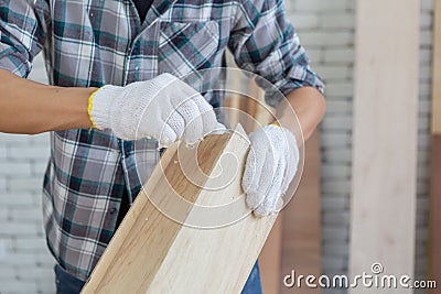 Closeup hands of asian carpenter holding bottle of glue working on wooden job Stock Photo