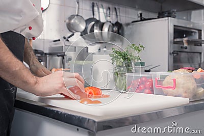 Closeup hands chef kitchen, cutting tomatoes Stock Photo