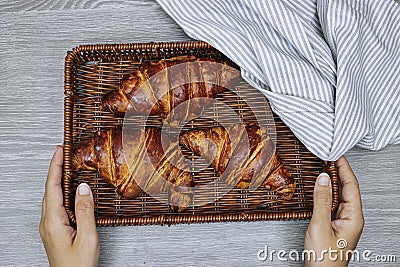closeup hands holding a esparto halfah basket with Fresh croissants . Stock Photo