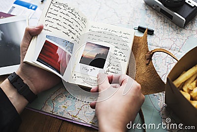 Closeup of hands holding journey diary notebook over map background Stock Photo